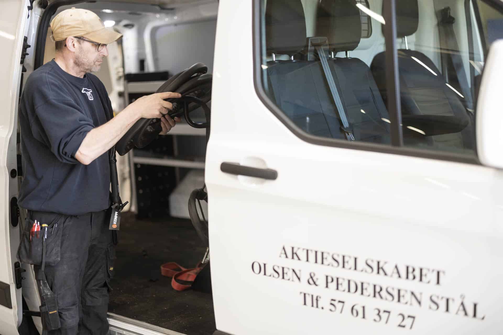 Mobile fitter beside an Olsen & Pedersen service vehicle